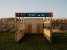 An axe throwing area with wooden targets and a sign at The Weir in North Berwick