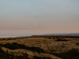 A landscape view with a moon over the ocean at The Weir in North Berwick