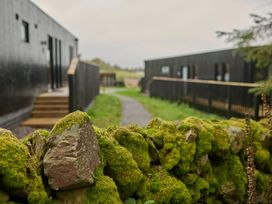 An outdoor view with mossy stones and wooden path at Orka 1.0 Spa (Pet) Dumfries