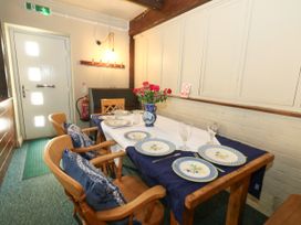 A dining room with a table set for dinner at The Old Barn in Stourton Caundle near Stalbridge