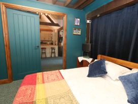 A bedroom with a bed and door at The Old Barn in Stourton Caundle near Stalbridge