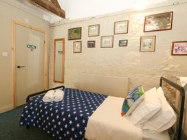 A bedroom with a bed and wall pictures at The Old Barn in Stourton Caundle near Stalbridge