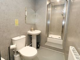 A bathroom with a toilet, washbasin, and shower at The Old Barn in Stourton Caundle near Stalbridge