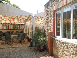 An outdoor area with tables and chairs under a tent at The Old Barn in Stourton Caundle near Stalbridge
