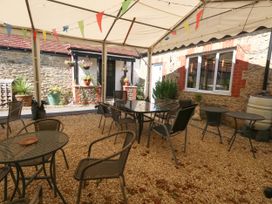 An outdoor seating area with tables and chairs at The Old Barn in Stourton Caundle near Stalbridge