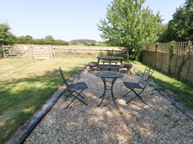 A garden with a table and chairs at The Old Barn in Stourton Caundle near Stalbridge