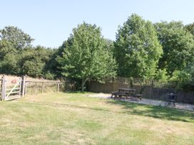 A garden with a picnic table and trees at The Old Barn in Stourton Caundle near Stalbridge