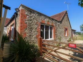 A stone house with a garden gate at The Old Barn in Stourton Caundle near Stalbridge