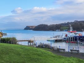 A pier with a boat on the water at New build at Tyn Pwll in Llanfairpwllgwyngyll