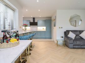 A kitchen with a kitchen island and bar stools at Pistyll Ddu in Brynsiencyn near Llanfairpwllgwyngyll