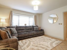 A living room with a sofa and lamp at Pistyll Ddu Brynsiencyn near Llanfairpwllgwyngyll