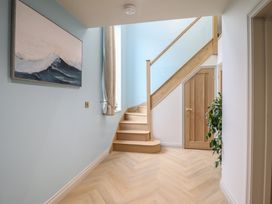 A hallway with a staircase and artwork at Pistyll Ddu in Brynsiencyn near Llanfairpwllgwyngyll
