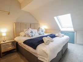 A bedroom with a bed and window at Pistyll Ddu in Brynsiencyn near Llanfairpwllgwyngyll