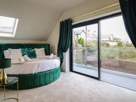 A bedroom with a round bed and glass doors at Pistyll Ddu, Brynsiencyn near Llanfairpwllgwyngyll