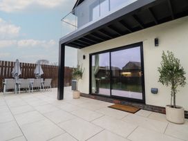 An outdoor patio with table and chairs at Pistyll Ddu in Brynsiencyn near Llanfairpwllgwyngyll