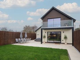 A house with patio furniture and a grass area at Pistyll Ddu in Brynsiencyn near Llanfairpwllgwyngyll