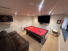 A game room with a pool table and dartboard at Pistyll Ddu in Llanfairpwllgwyngyll