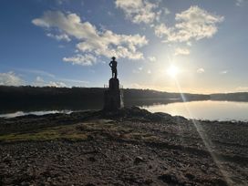 A statue on a rocky shore during sunset at Pistyll Ddu in Llanfairpwllgwyngyll