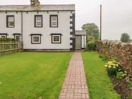 An exterior view of a house with a garden and pathway at Orchard Cottage in Appleby-in-Westmorland