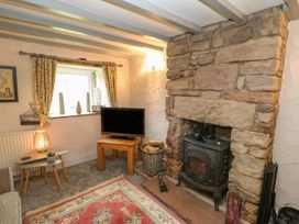 A living room with a television and wood stove at Orchard Cottage in Appleby-in-Westmorland