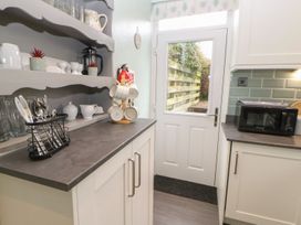 A kitchen with countertop, microwave, and glassware at Orchard Cottage in Appleby-in-Westmorland
