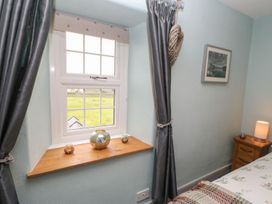 A bedroom with a window and decorative items on the sill at Orchard Cottage in Appleby-in-Westmorland