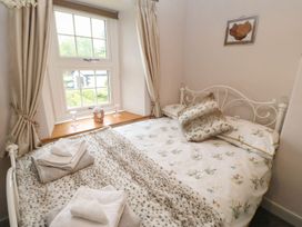 A bedroom with a bed and curtains at Orchard Cottage in Appleby-in-Westmorland