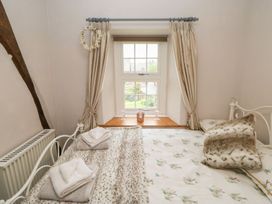 A bedroom with two beds and a window at Orchard Cottage in Appleby-in-Westmorland
