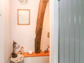 A hallway featuring a wooden beam and decorative items at Orchard Cottage in Appleby-in-Westmorland