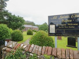 A church surrounded by hedges and a path at All Saints Church in Bolton