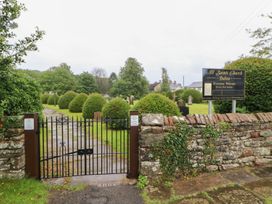 A gate leading to All Saints Church with a sign in Bolton