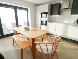 A dining room with a table and chairs at Glynllifon 4 in Marianglas