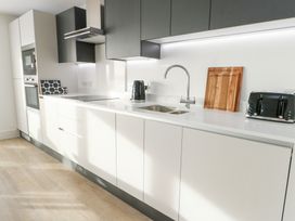 A kitchen with cabinets and appliances at Glynllifon 4 in Marianglas