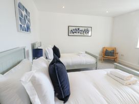 A bedroom with two beds and artwork at Glynllifon 4 in Marianglas