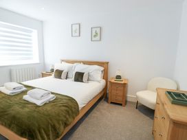 A bedroom with a bed and small furniture at Glynllifon 4 in Marianglas