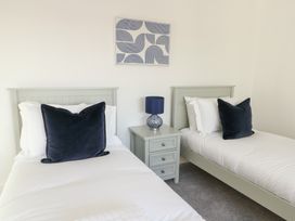 A bedroom with two beds and a nightstand at Glynllifon 4 in Marianglas