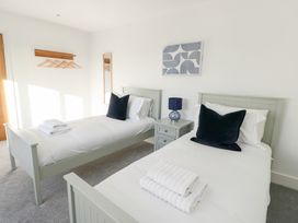 A bedroom with two single beds and a nightstand at Glynllifon 4 Marianglas