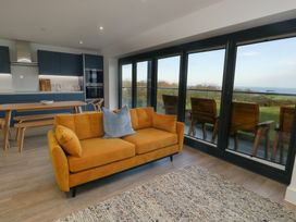 A living room with a sofa and table at Glynllifon 6 in Marianglas