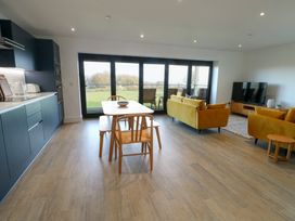 A living room with a kitchen and dining area at Glynllifon 6 in Marianglas