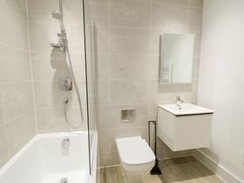 A bathroom with shower, bathtub, toilet, and sink at Glynllifon 6, Marianglas