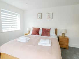 A bedroom with a bed and lamp at Glynllifon 6 in Marianglas