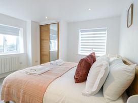 A bedroom with a bed and pillows at Glynllifon 6 in Marianglas