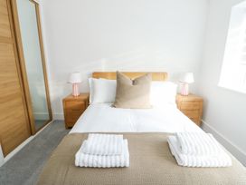 A bedroom with a bed and nightstands at Glynllifon 6 in Marianglas