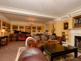 A living room with a piano and a sofa at Ladye Park in Liskeard