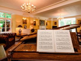 A living room with a piano and sheet music at Ladye Park in Liskeard
