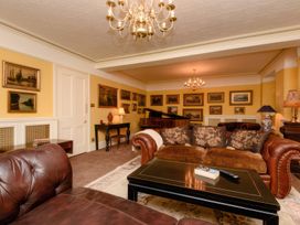 A living room with sofa and chandelier at Ladye Park in Liskeard