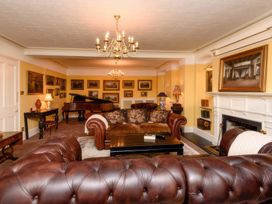 A living room with a piano and sofa at Ladye Park in Liskeard