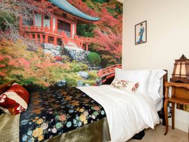 A bedroom with bed and a mural of a Japanese temple at Ladye Park in Liskeard