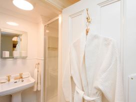 A bathroom with a sink, mirror, and shower at Ladye Park in Liskeard