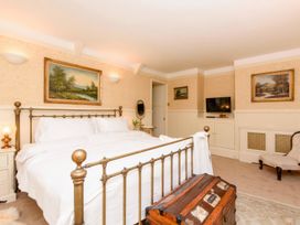 A bedroom with a bed, television, and paintings at Ladye Park in Liskeard